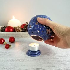 a hand is holding a blue ball with stars on it and some red balls around it