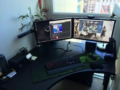 two computer monitors sitting on top of a desk next to a keyboard, mouse and monitor