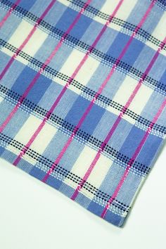 a blue and white checkered tie laying on top of a white table with pink trim