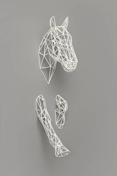 three pieces of white wire sitting on top of a gray surface next to each other