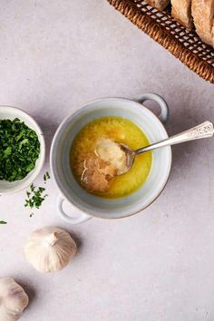 a bowl filled with soup next to garlic and bread