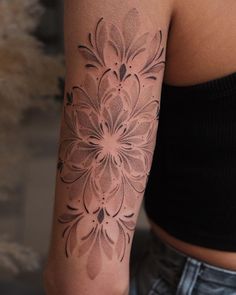 a woman's arm with a flower tattoo on the left side of her arm