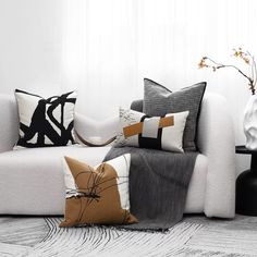 a white couch sitting next to a black table with two vases on top of it