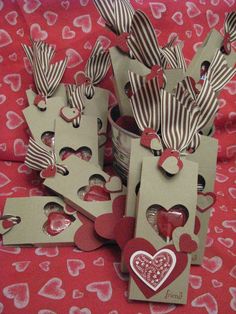 several small boxes with hearts on them sitting on a red and white cloth covered surface