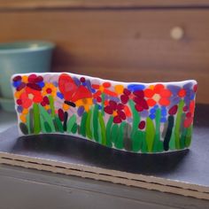 a colorful glass vase sitting on top of a table