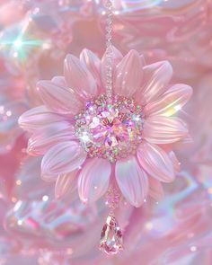 a pink flower hanging from a chain with a crystal bead on it's center