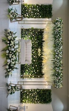 an indoor wedding setup with white flowers and greenery on the walls, along with chairs