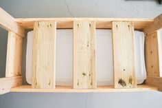 a wooden shelf with two white dishes in it and some wood planks on the bottom