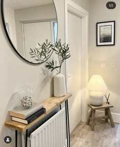 a mirror on the wall above a radiator in a room with white walls and wood flooring