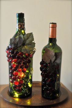 two wine bottles decorated with grapes and leaves