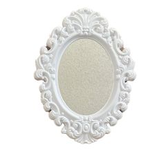 a white oval mirror with an ornate design on the front and back side, against a white background