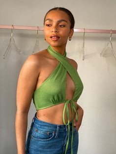 Elevate your style with the captivating Suki Green Halter Neck Crop Top. This stunning addition to your wardrobe is designed to make a statement and turn heads wherever you go. Crafted from a luxurious micro speckle green fabric, this crop top boasts a halter neck design that exudes elegance and sophistication. The open bust and tie front add a touch of allure, while the low back detail creates a unique and stylish look that is sure to impress. Not only does the Suki Green Halter Neck Crop Top o Chic Green Halter Top For Party, Green Stretch Halter Neck Top, Spring Party Halter Crop Top, Spring Party Crop Top Halter, Green Tops For A Night Out In Spring, Glamorous Green Fitted Tops, Green Fitted Glamorous Top, Glamorous Fitted Cropped Halter Top, Fitted Glamorous Green Tops