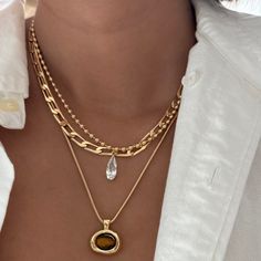 This delicate necklace features a gold-filled beaded chain paired with a stunning clear cubic zirconia teardrop charm. The brilliant teardrop adds just the right amount of sparkle, making it perfect for layering or wearing alone for a subtle yet elegant statement. 14k Gold Filled Beaded Chain 16k Clear CZ Teardrop Charm: 17mm x 6.9mm Chain length: 16" with 2" extender Lobster clasp closure Hypoallergenic Water resistant & tarnish free Nickel & lead free Elegant Gold Crystal Necklaces For Layering, Elegant Gold Crystal Necklace For Layering, Gold Teardrop Pendant Necklace For Layering, Gold Teardrop Crystal Necklace With Delicate Chain, Gold Teardrop Drop Necklace, Gold Teardrop Crystal Necklace, Gold Teardrop Pendant Crystal Necklace Dainty Style, Gold Teardrop Dainty Chain Necklace, Gold Teardrop Drop Necklace For Layering