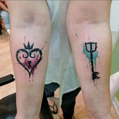 two people with matching tattoos on their legs, one has a key and the other has a heart