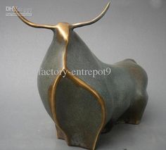 an animal statue is shown on a gray surface with gold trimmings and curved horns