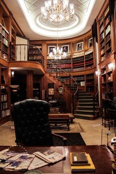 a room with lots of books on shelves and a chandelier hanging from the ceiling