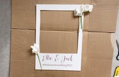 the wedding photo frame is made out of cardboard with flowers and scissors next to it