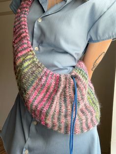 a woman wearing a colorful knitted arm warmer with blue string attached to the arm