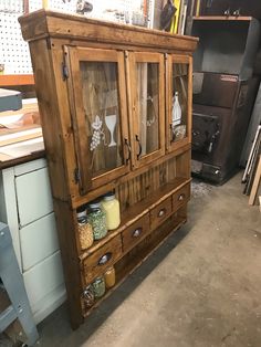 an old wooden cabinet with glass doors and drawers