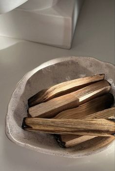 a bowl filled with wooden sticks on top of a white counter