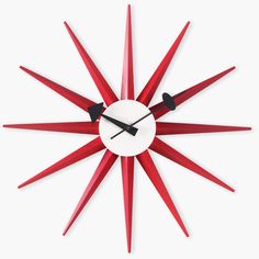 a red and white clock with black hands on it's face in the shape of a star