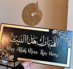 a person holding up a sign that says may aloh bess this home in arabic