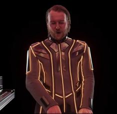 a man in a futuristic suit playing the piano