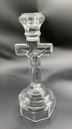 a clear glass candle holder with a cross on it