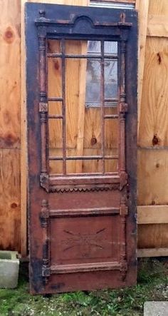 an old wooden door sitting in the grass