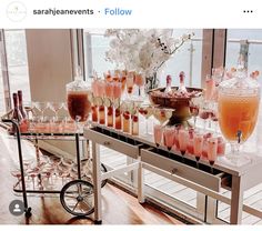 a table filled with lots of different types of drinks on top of a wooden floor