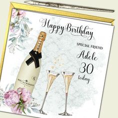 a happy birthday card with two champagne glasses and a bottle of wine in front of it