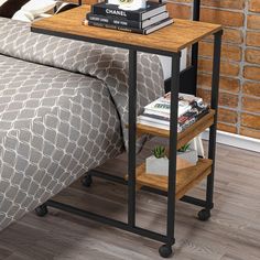 a bed with a gray bedspread and a wooden end table next to it