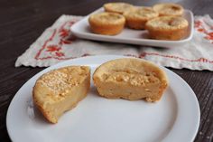 two white plates topped with mini pies on top of a wooden table