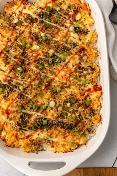 a casserole dish with cheese, green onions and other toppings on top