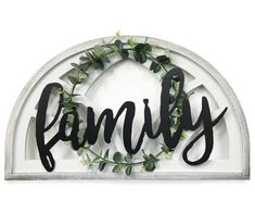 a metal sign that says family with greenery around the letters in black and white