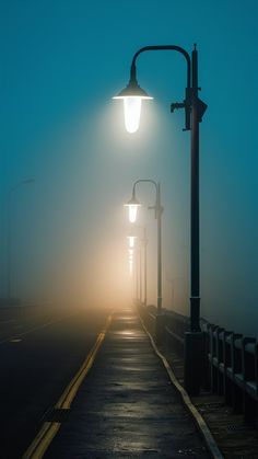 a street light sitting on the side of a foggy road