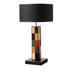 a multicolored table lamp with a black shade on the base and a black lampshade