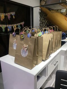 brown paper bags with decorations on them are sitting on a counter in front of a store