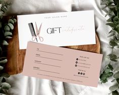 a pair of scissors and a gift certificate on top of a wooden cutting board with greenery