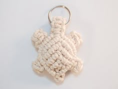 a crocheted keychain is shown on a white surface with a metal ring