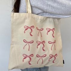 a woman holding a bag with pink bows on it