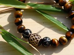 Pretty bracelet with Tiger’s Eye and a beautiful, handmade and hand-carved Palm-Seed Bead. a special boost Tibetan Symbols, Pictures On String, Tibetan Bracelet, Eco Jewelry, Pretty Bracelets, Natural Shades, Pillow Gift, Plexus Products