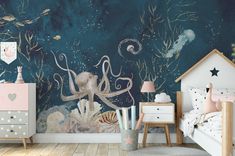 a child's bedroom with an octopus mural and sea creatures on the wall behind it