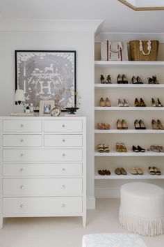 a white closet with lots of shoes on the shelves