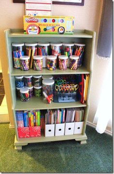 a book shelf filled with lots of books and crafting supplies on top of it