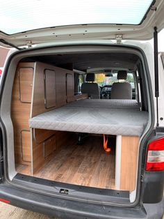 the back end of a van with an open hatchback door and mattress on it