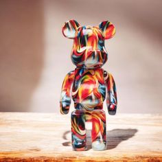 a colorful bear sitting on top of a wooden table