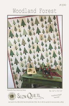 the woodland forest quilt pattern is displayed on a table next to a green desk and chair