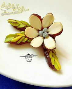 a white plate topped with a flower shaped brooch