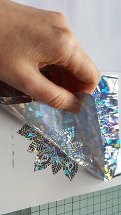 a person holding onto a piece of paper with an intricate design on the bottom half